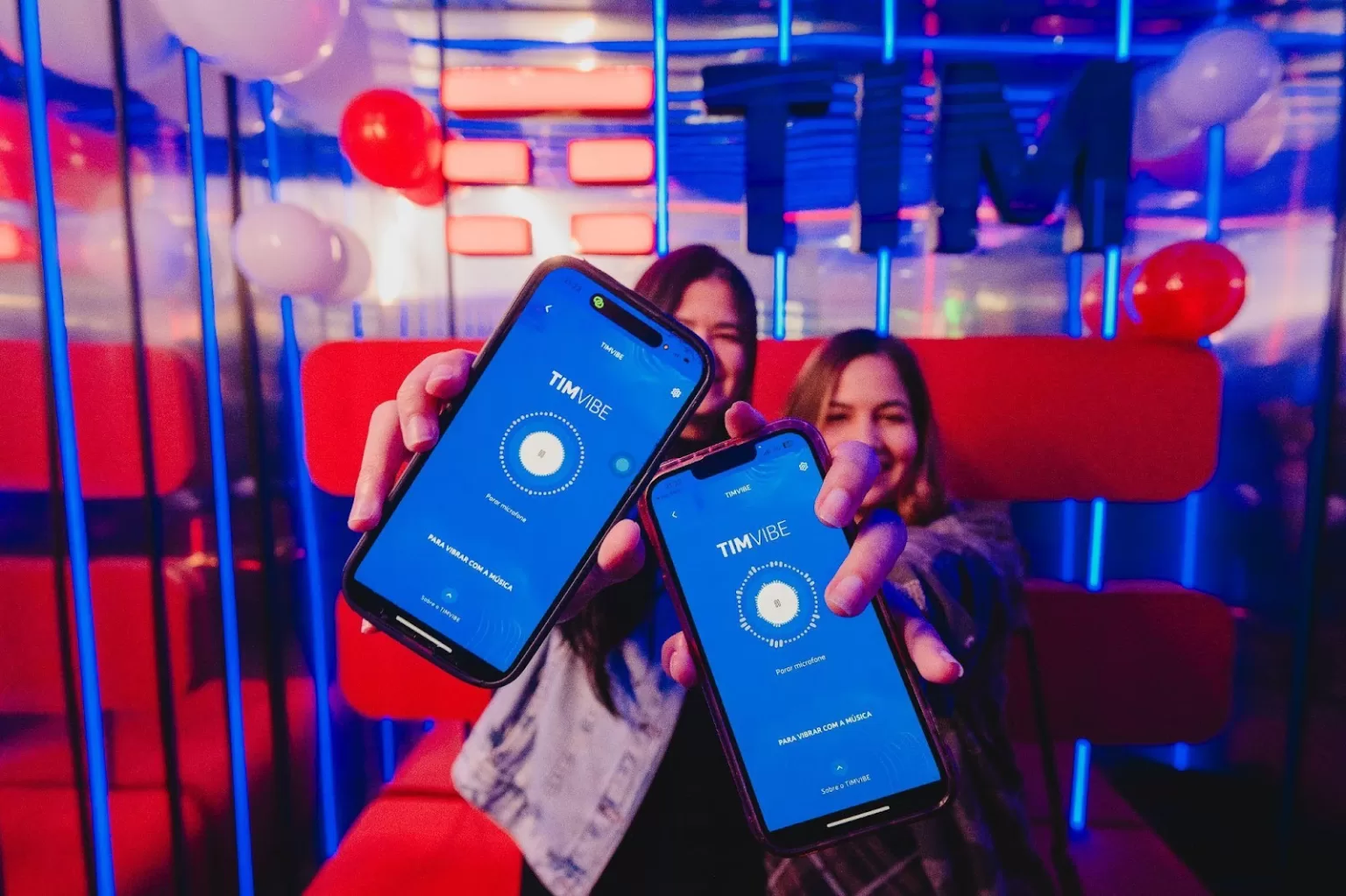 duas mulheres com celular na mão